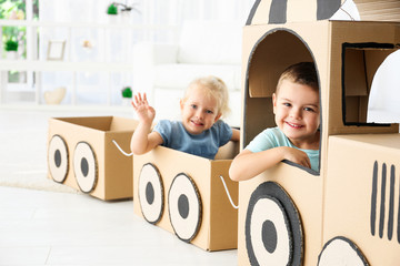 Canvas Print - Little children playing with cardboard train in light room