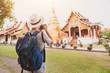 travel to Asia, tourist photographer taking photo of temple or landmark, tourism in Thailand