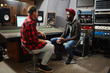 © pressmaster - Operator of audio studio having talk with young musician about releasing new album