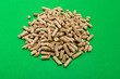 Pellets Biomass. Wood pellets on a green background , copy space