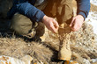 Close-up of a traveler in the mountains in winter tying shoelaces on his shoes