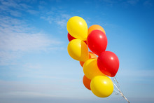 Yellow And Red Balloons On A Blue Sky Background