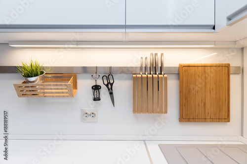 Fotografía kitchenware hanging on the rail in the white glossy kitchen