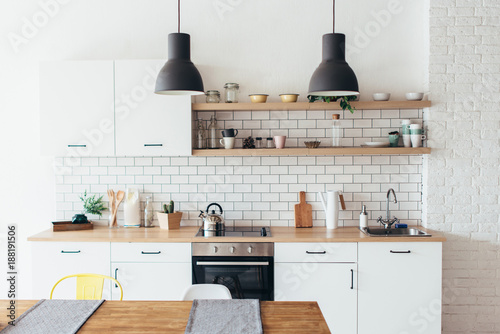 Photographie Modern new light interior of kitchen with white furniture and dining table