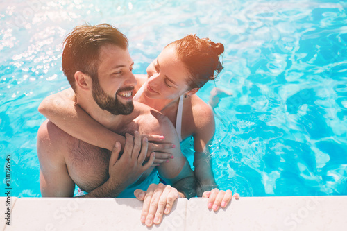Fotografía Cheerful youthful guy and lady resting while swimming pool outdoor