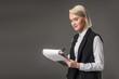 © LIGHTFIELD STUDIOS - portrait of stylish businesswoman making notes in notepad isolated on grey