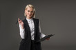 © LIGHTFIELD STUDIOS - portrait of stylish businesswoman with notepad isolated on grey