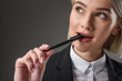 © LIGHTFIELD STUDIOS - portrait of beautiful young businesswoman with pen isolated on grey