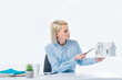 © LIGHTFIELD STUDIOS - portrait of real estate agent pointing at house model in hand at workplace