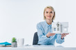 © LIGHTFIELD STUDIOS - portrait of real estate agent showing house model at workplace