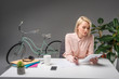© LIGHTFIELD STUDIOS - beautiful young businesswoman using tablet at workplace isolated on grey