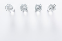 Top View Of Row Of Small Glasses With Water On White Table