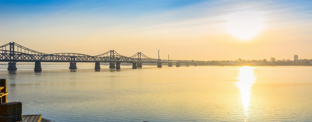  Yalu River Bridge and Yalu River Scenic Areas at morning. In the distance is North Korea. Located in Dandong, Liaoning, China.
