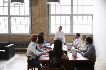 Wall Mural - Business colleagues at meeting looking to female manager