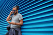 © Syda Productions - man with earphones and smartphone over wall