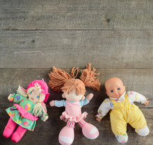 Dolls On Wooden Background. Top View. Copy Space.