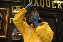 Professional Artist Or Artisan Craftsman, Wears Protection Yellow Suit And Gas Mask, For Air Filtering Before Painting Or Spraying With Paint And Dangerous Chemicals