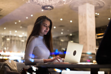 Young beautiful female student, write school paper or freelancer works on project at cafeteria or coworking hub, writes code for startup company, successful woman empowered and independent