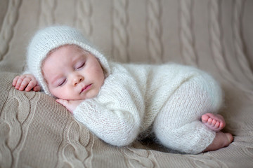 Poster - Beatiful baby boy in white knitted cloths and hat, sleeping