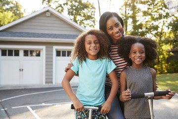 Wall Mural - Mother With Children Riding Scooters On Driveway At Home