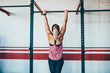 © Criene Images - Strong female athlete doing pull up in gym
