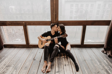 Wall Mural - beautiful sexy girl and her boyfriend playing guitar