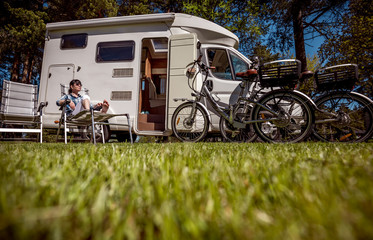 Wall Mural - Woman resting near motorhomes in nature. Family vacation travel, holiday trip in motorhome RV, Caravan car Vacation.