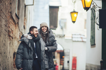 Classy groom and his gorgeous bride pose outside in winter coats 