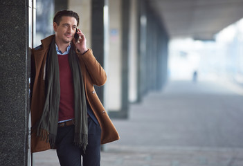 Aufkleber - Portrait of smiling man speaking by mobile while locating in street. Communication concept. Copy space