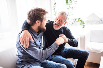 Wall Mural - Hipster son with his senior father at home.