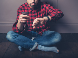 Young man on wooden floor with smart watch