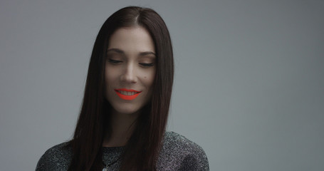 Wall Mural - closeup of spanish woman with vivid orange matte lipstick in studio. Straight hair and ideal skin