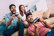 © Mediteraneo - Group of friends play video games together.
