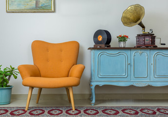 vintage interior of retro orange armchair, vintage wooden light blue sideboard, old phonograph (gram