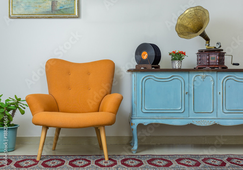 Fotografie, Obraz Vintage interior of retro orange armchair, vintage wooden light blue sideboard,