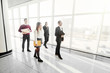 © F8  \ Suport Ukraine - Full length of group of happy young business people walking the corridor in office together. Walk team.