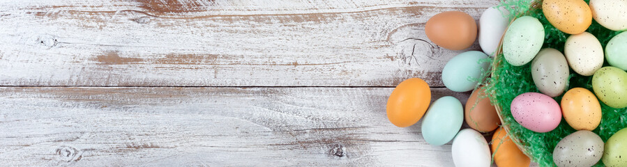 Sticker - Top view of Easter eggs inside of basket with grass on white rustic wood