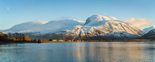 Landscape View Of Scotland And Ben Nevis Near Fort William In Winter With Snow Capped Mountains And Calm Blue Sky And Water