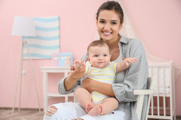 Canvas Print - Mother and cute baby sitting on chair after bathing at home