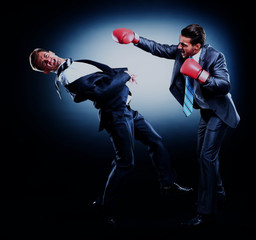 Wall Mural - Two young businessman boxing againts dark background.