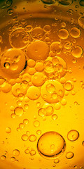 Yellow background cooking, olive oil drops and bubbles in water, kitchen background.