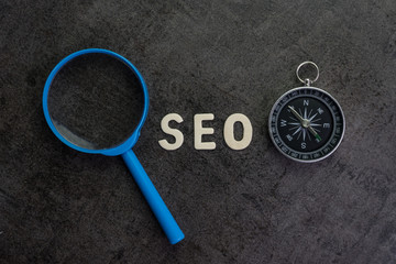 Aufkleber - magnifier, wood alphabet seo and compass on chalkboard background using as seo search engine optimiz