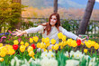 beautiful woman with tulips flowers in garden