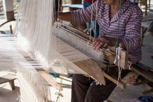 Woman Weaving Silk In Traditional Way At Manual Loom. Thailand