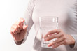 © PORNCHAI SODA - isolate of the women hand holding the medicine with a glass of water, medicine recovery concept