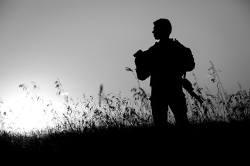 military soldier with weapons at sunset. shot, holding gun, colorful sky. military concept.