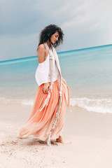 Wall Mural - beautiful young stylish woman in pink skirt on the beach