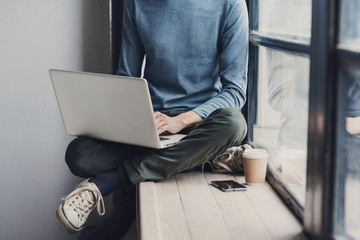 Man student using laptop computer. Male hands typing on laptop keyboard