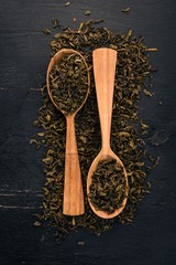 Wall Mural - Dry green tea. On a wooden background. Top view. Copy space.