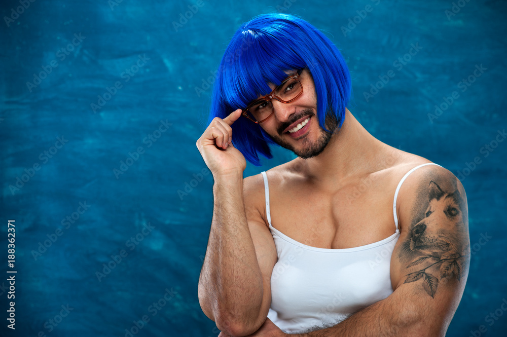Portrait of cute young male cross dressing person wearing blue wig and  glasses. Place for text Stock Photo | Adobe Stock